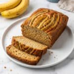 banana bread recipe golden moist loaf sliced on white plate