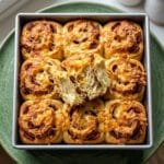cheese and bacon scrolls golden melted cheddar in a baking tin